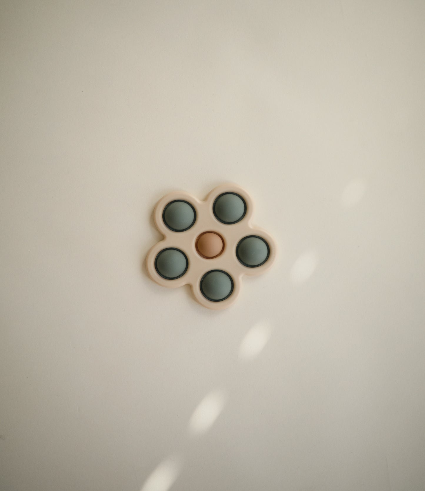 Presstoy van het merk Mushie in de vorm van een bloem, bijtspeeltje mushie in kleur "Dried Thyme" voor baby en peuter, motorisch speelgoed