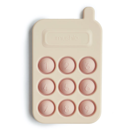 Presstoy van het merk Mushie in de vorm van een telefoon/phone, bijtspeeltje mushie in kleur "Blush" voor baby en peuter, motorisch speelgoed